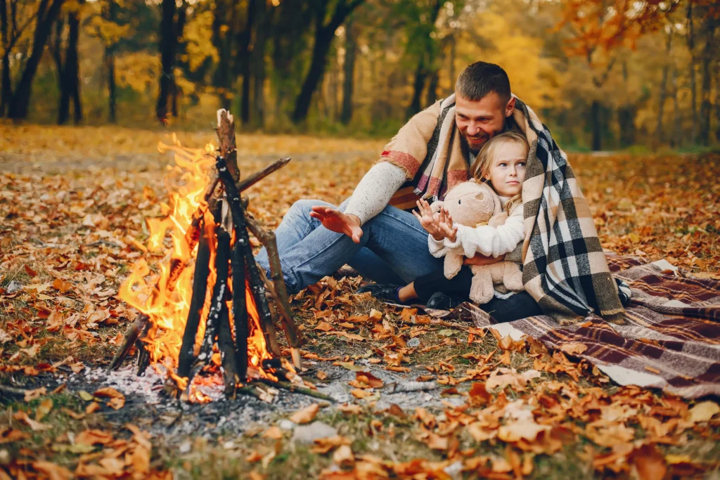 Cute family camping playing in a autumn park