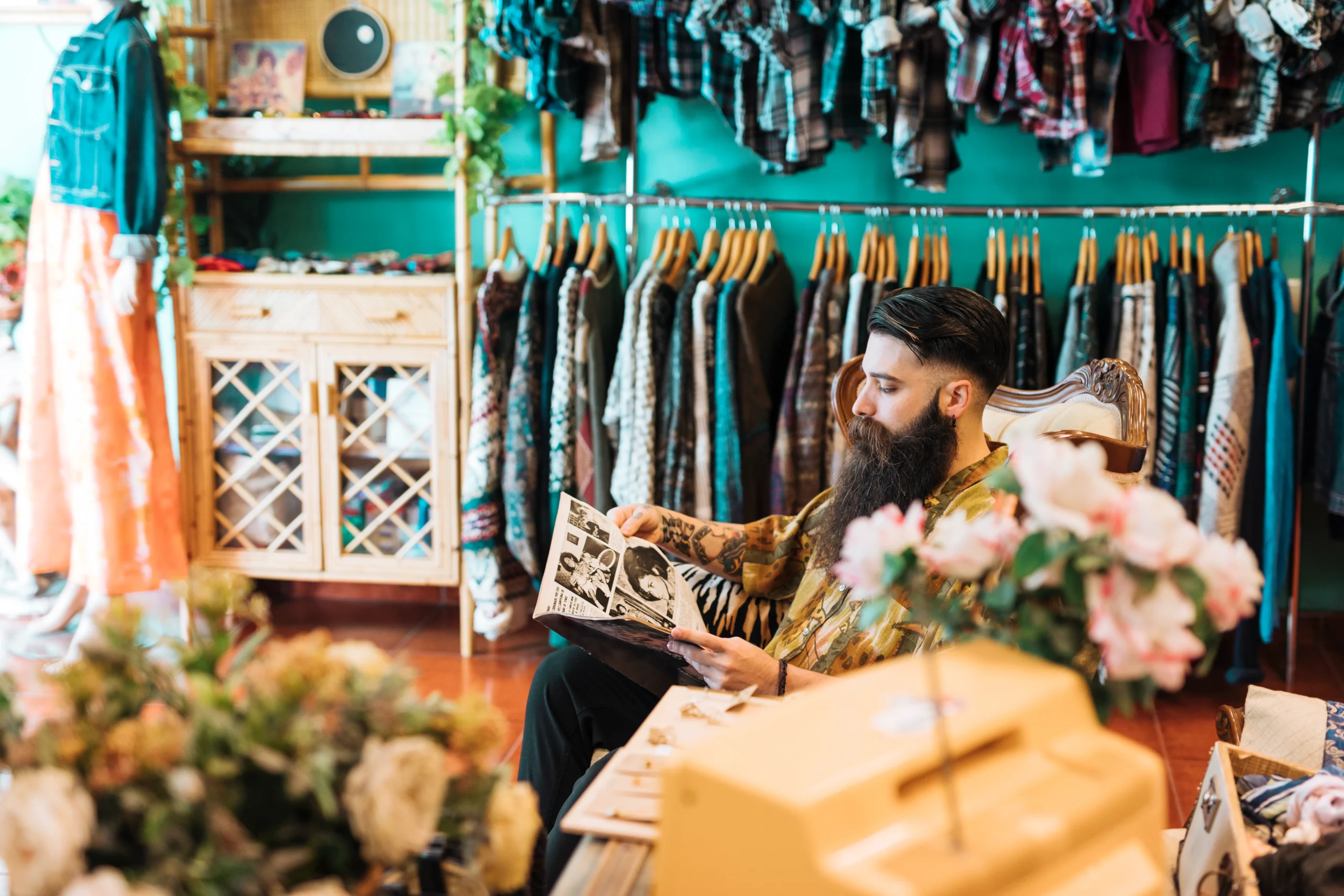Shop male owner sitting on chair in his local boutiques